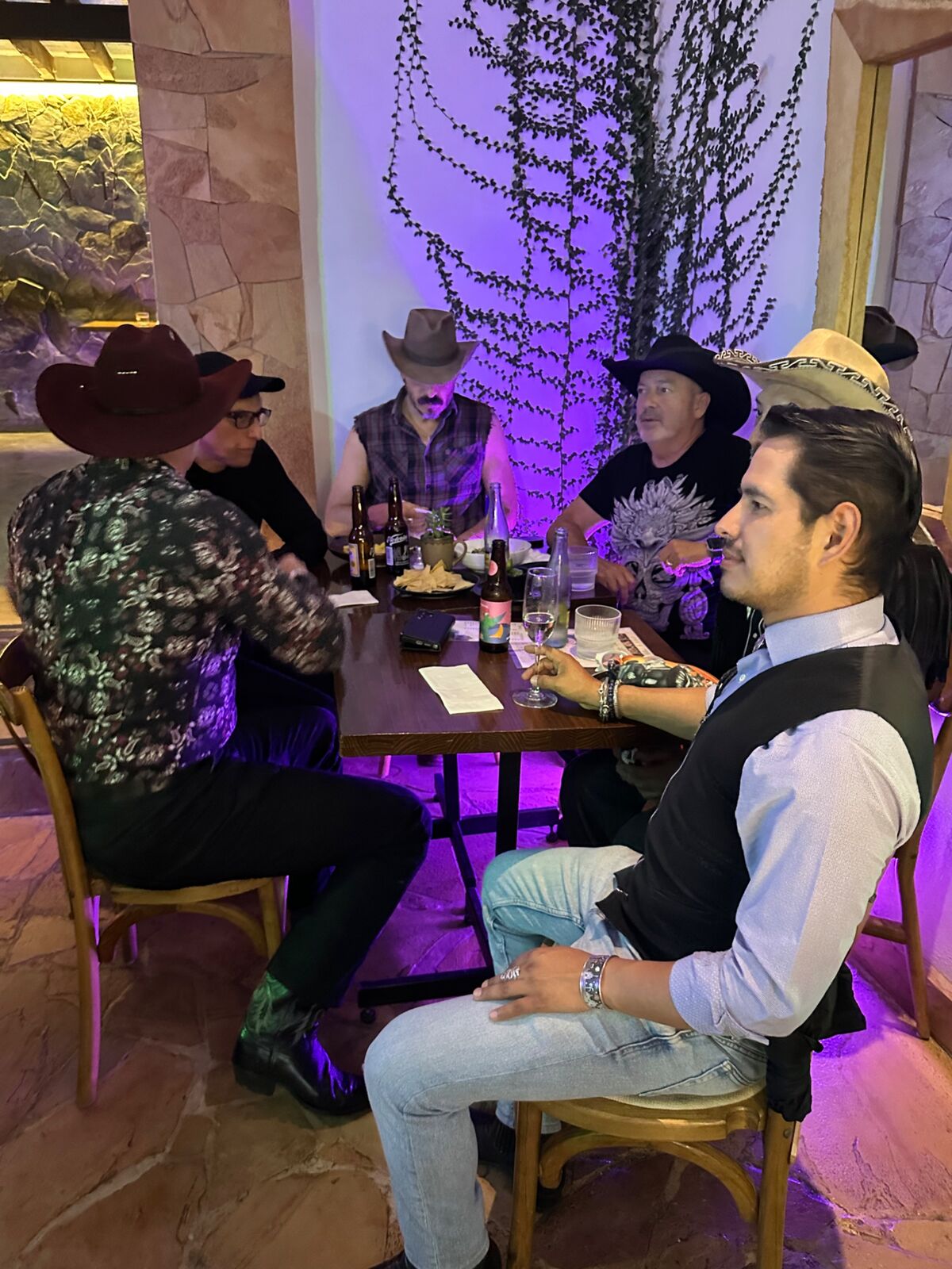 Clientes con sombrero vaquero en una noche temática con luz violeta